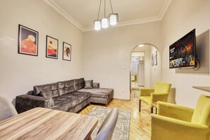A living room with a sectional sofa, a wooden coffee table, and a TV mounted on the wall. - The Blue House, Triplex, Best Location at Taksim (Istanbul)