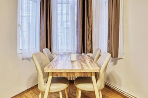 A dining table with six chairs, a white tablecloth, and a window with curtains. - The Blue House, Triplex, Best Location at Taksim (Istanbul)