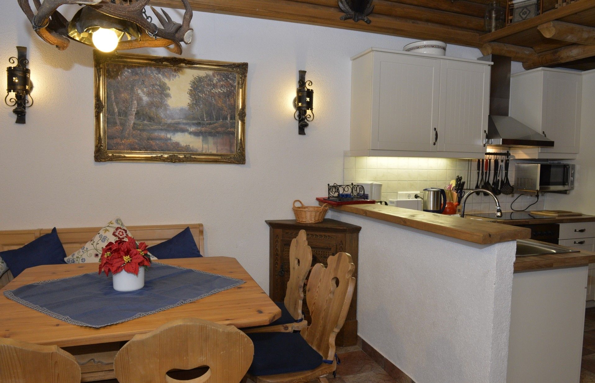 Uma sala de jantar com mesa de madeira, cadeiras e um quadro na parede.
