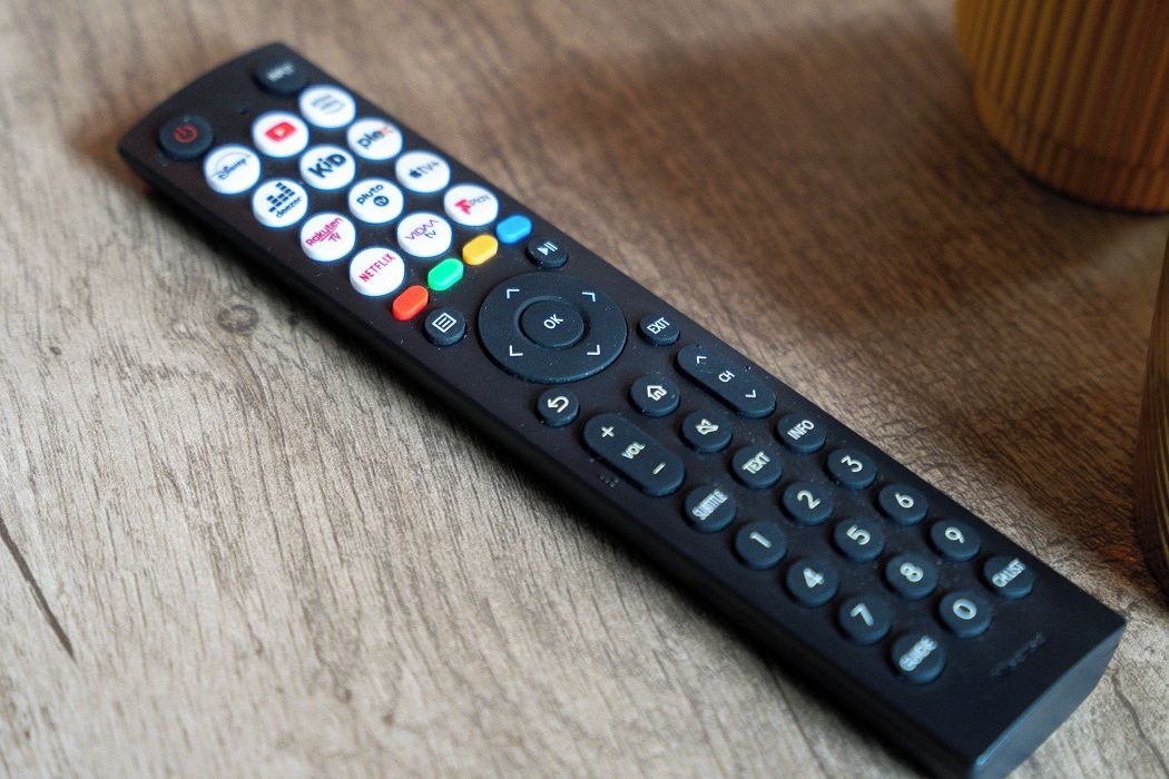 A black remote control with various buttons and symbols, including a numeric keypad and directional arrows.