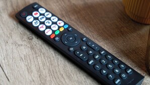 Un control remoto negro con varios botones y símbolos, incluyendo un teclado numérico y flechas direccionales.