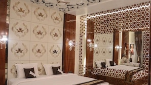Habitación de hotel con una cama grande, un espejo y papel tapiz estampado.