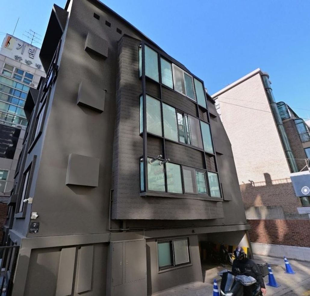 A multi-story building with a modern architectural design, featuring large windows and a flat facade.