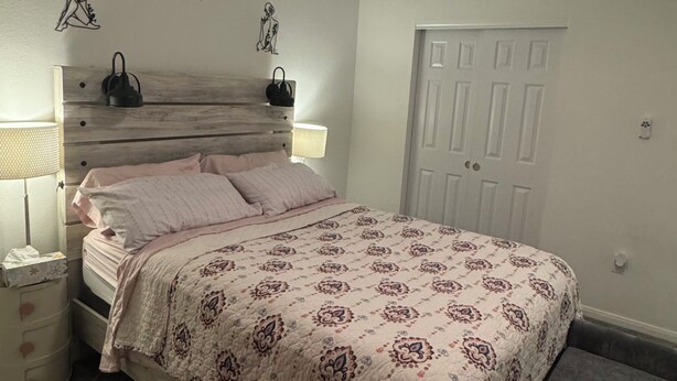 A bedroom with a bed, bedside tables, a ceiling fan, and a door. - Modern Furnished Retreat Cozy & Convenient (Castle Rock)