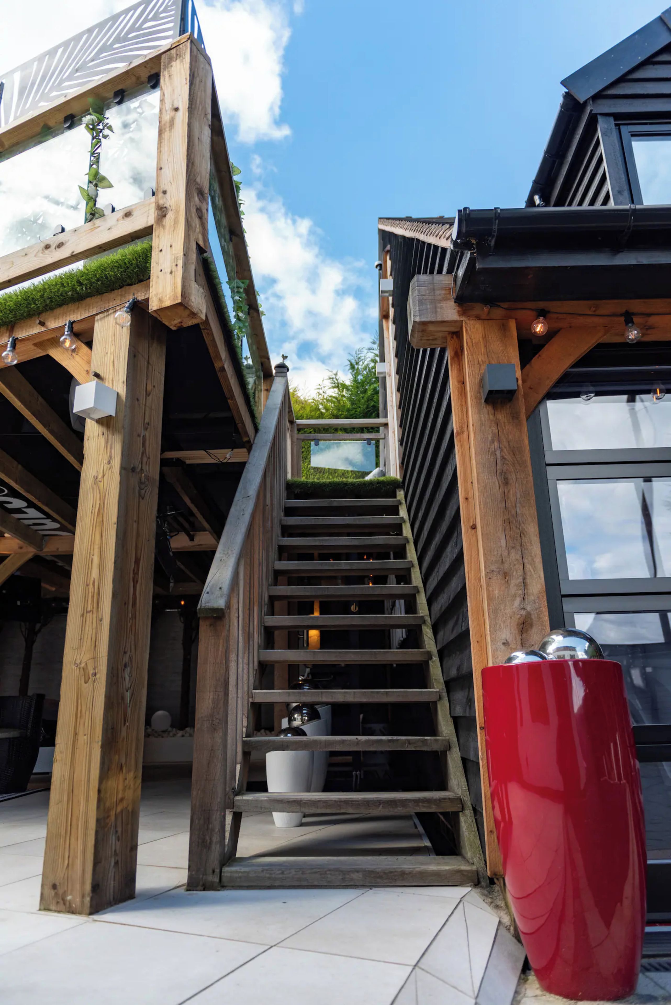 A wooden staircase leading to a covered area with a view of the sky.