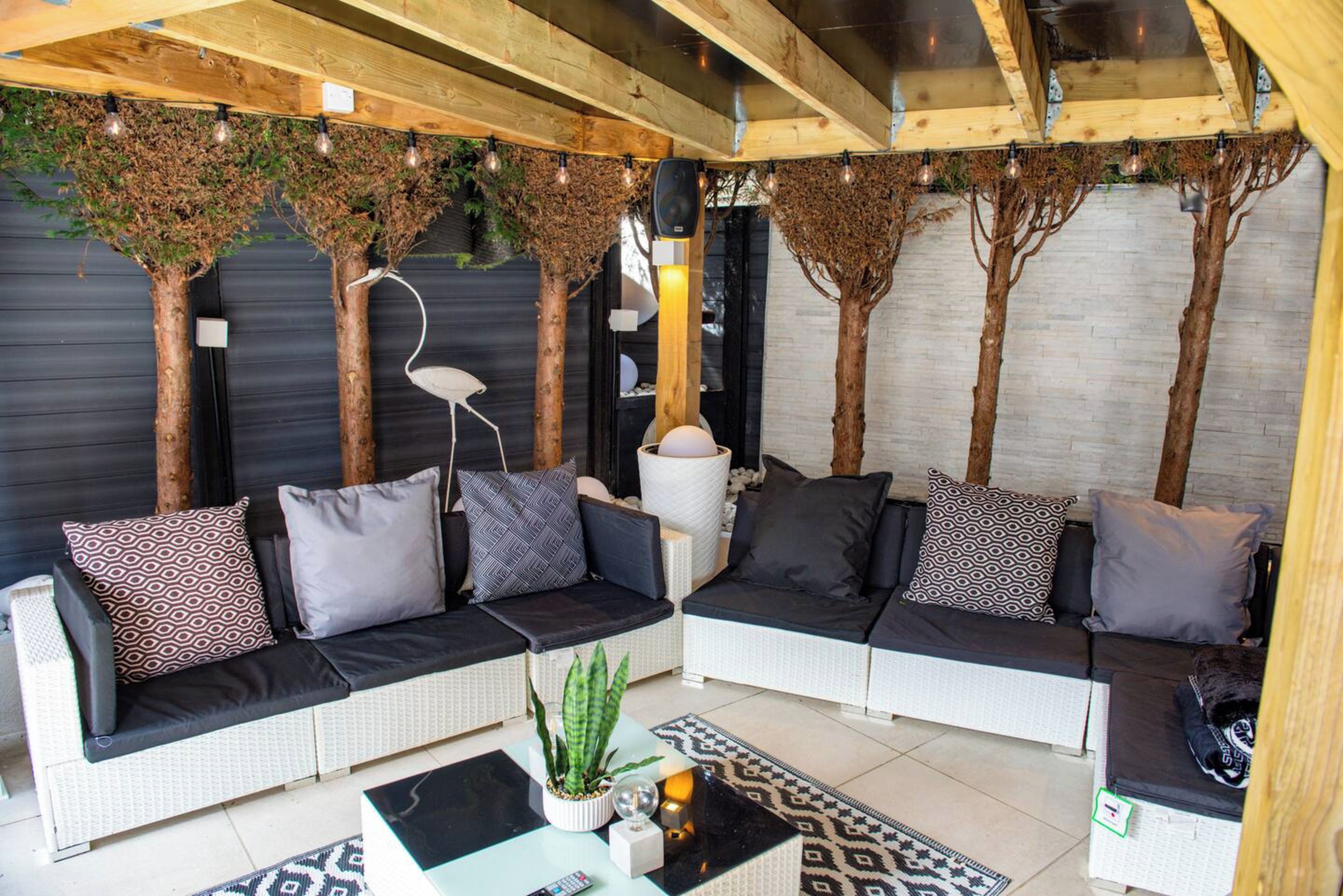 A modern living room with a sofa set, a coffee table, and decorative plants.