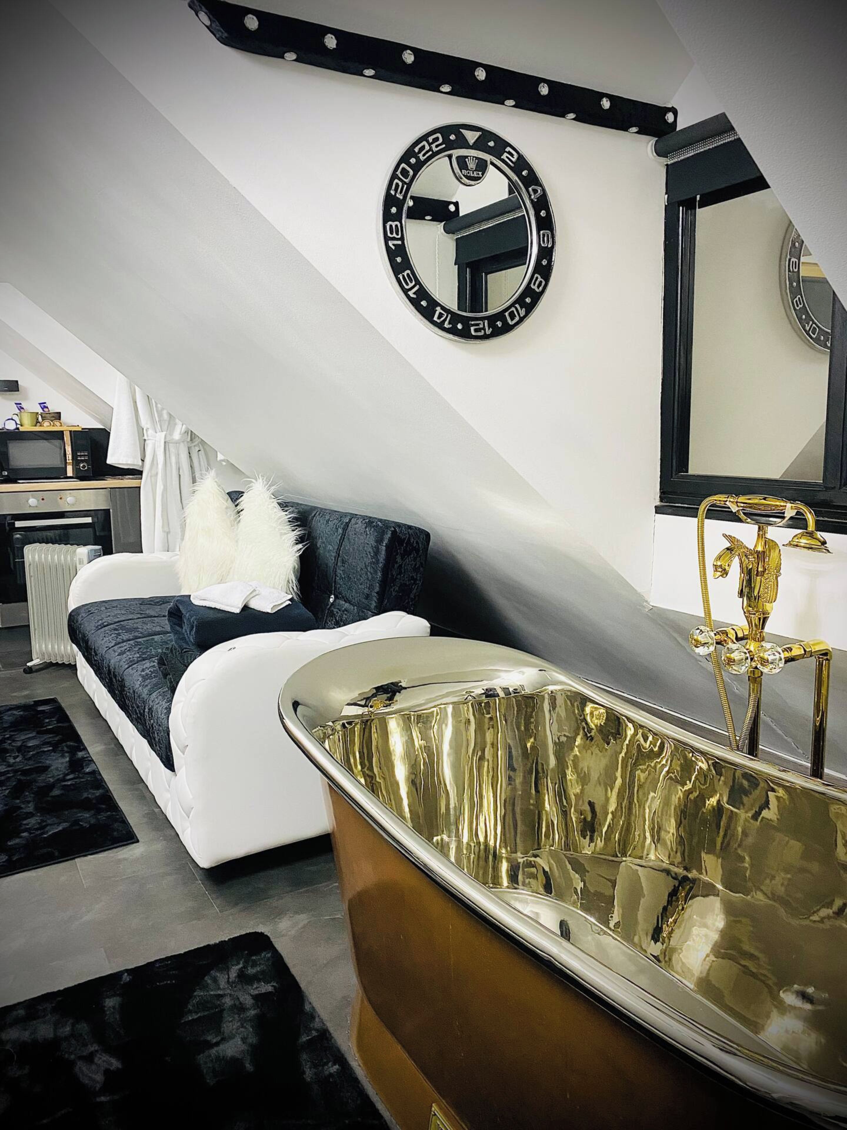A modern bathroom with a freestanding bathtub, a large mirror, and a towel rack.