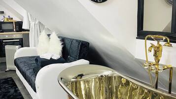 A modern bathroom with a freestanding bathtub, a large mirror, and a towel rack.