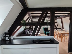 A kitchen with a black countertop, a coffee maker, and a can of coffee.