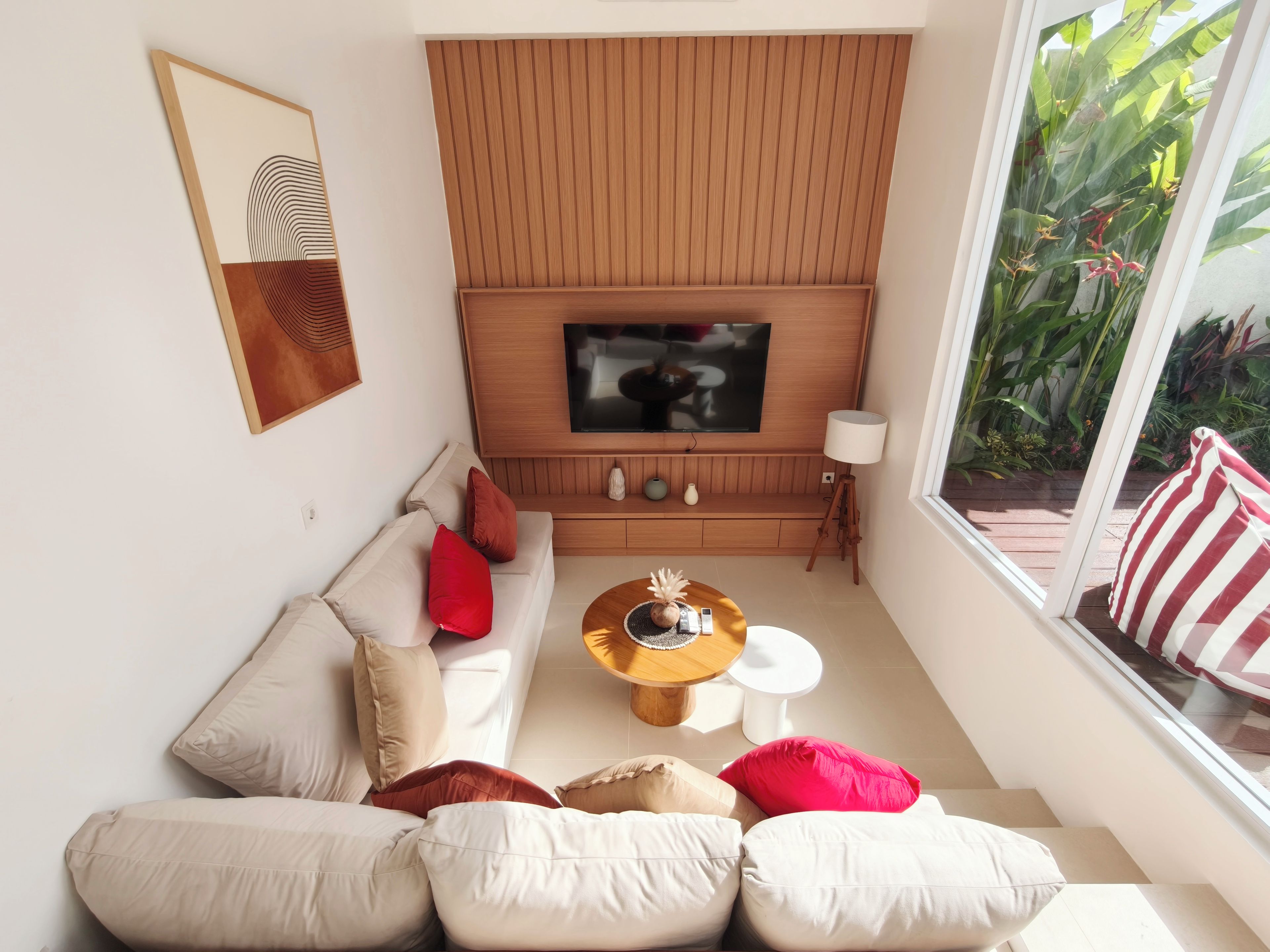 Una sala moderna con sofá, mesa de centro y televisor.