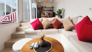 Uma sala de estar moderna com sofá, mesa de centro e vista para a cozinha.
