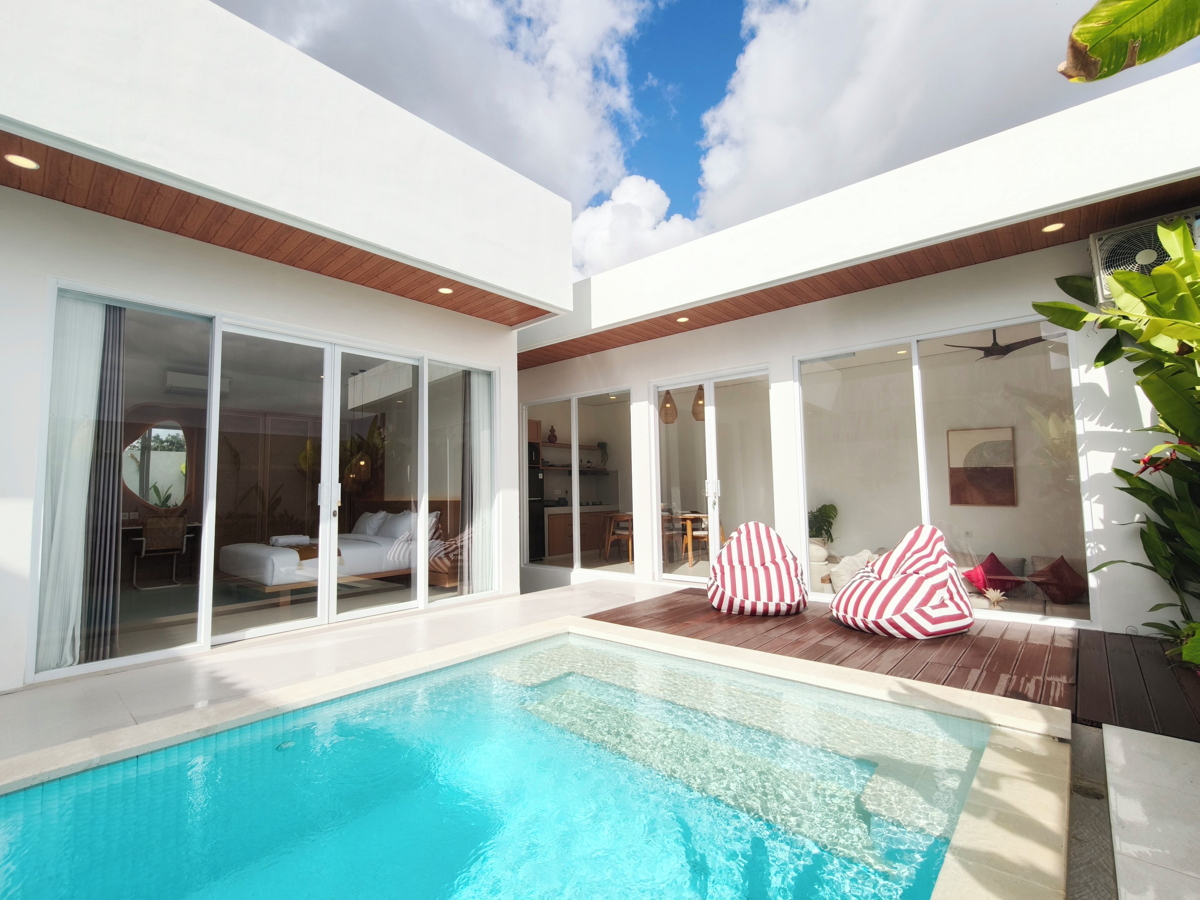 Una casa moderna con piscina, puertas correderas de vidrio y un comedor.