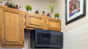A kitchen with wooden cabinets, a microwave, an oven, and a tiled backsplash. - 146-7 AA. Gorgeous 2-bedroom apartment with AC in New London (New London)