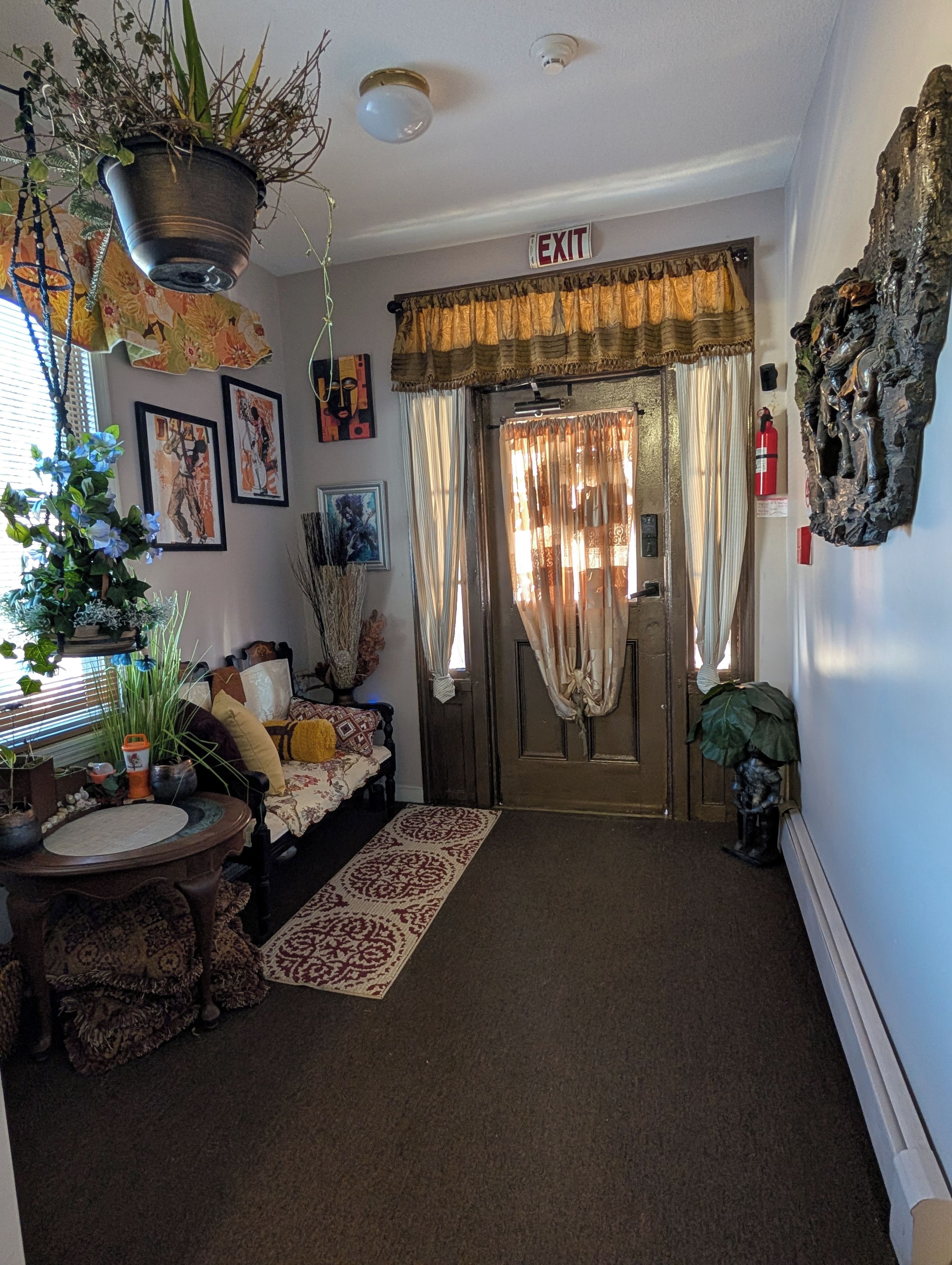 A cozy entryway with a bench, a rug, and a door marked 'EXIT'.