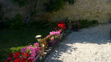Ein Gartenweg mit Blumenbeeten und einer Steinmauer.