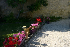 Ein Gartenweg mit Blumenbeeten und einer Steinmauer.