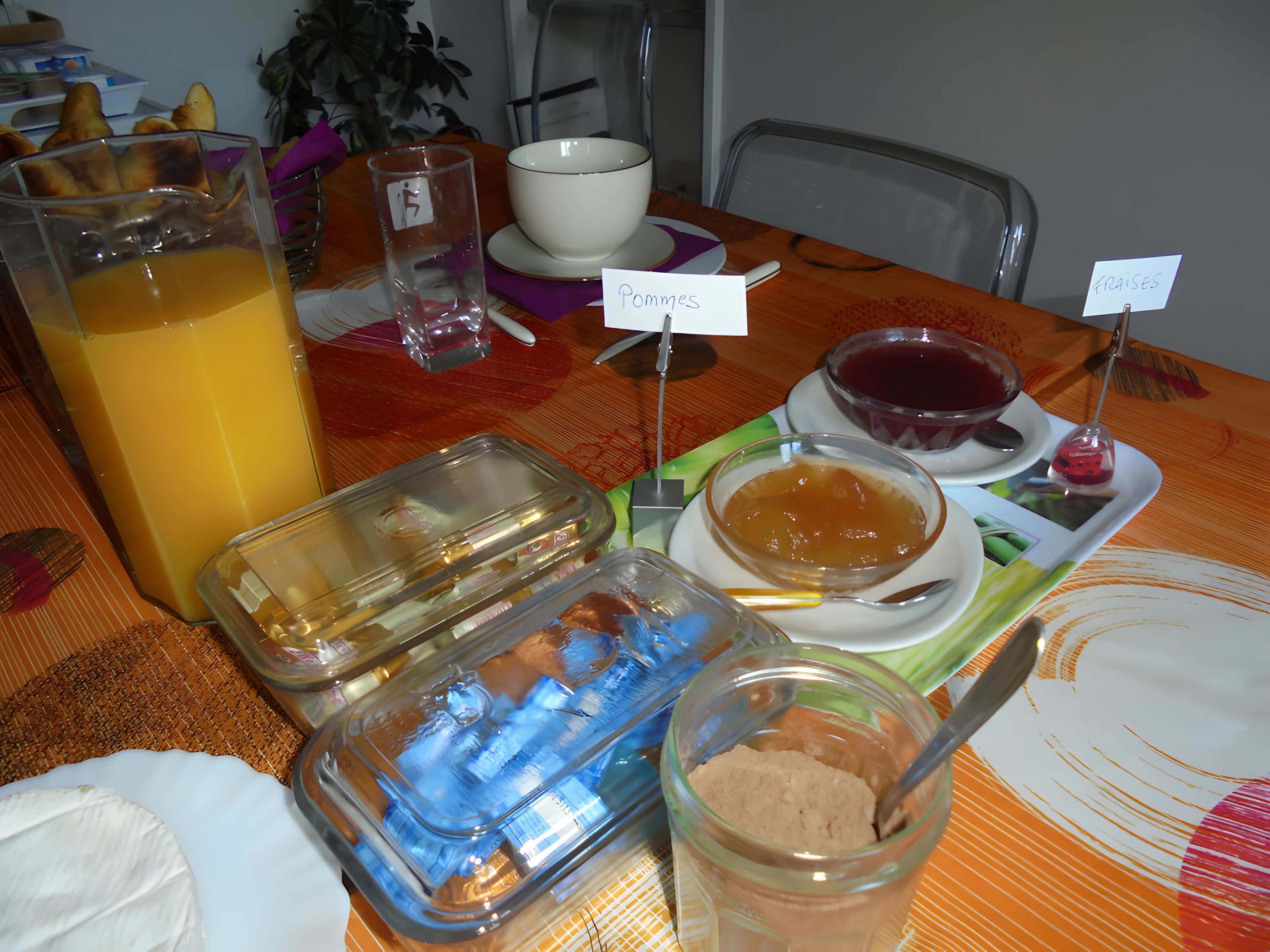 A table with various food items and a glass of orange juice.