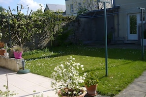 A well-maintained garden with various potted plants and a neatly trimmed lawn.