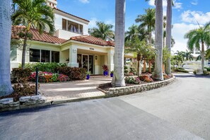 A two-story house with a number 6099, surrounded by palm trees and a well-maintained garden. - Resort Style Amenities + Quick Drive to Beach | Bahia Vista 478 (Saint Petersburg)
