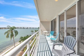 A balcony with a view of a bridge over water, furnished with chairs and a table. - Resort Style Amenities + Quick Drive to Beach | Bahia Vista 478 (Saint Petersburg)