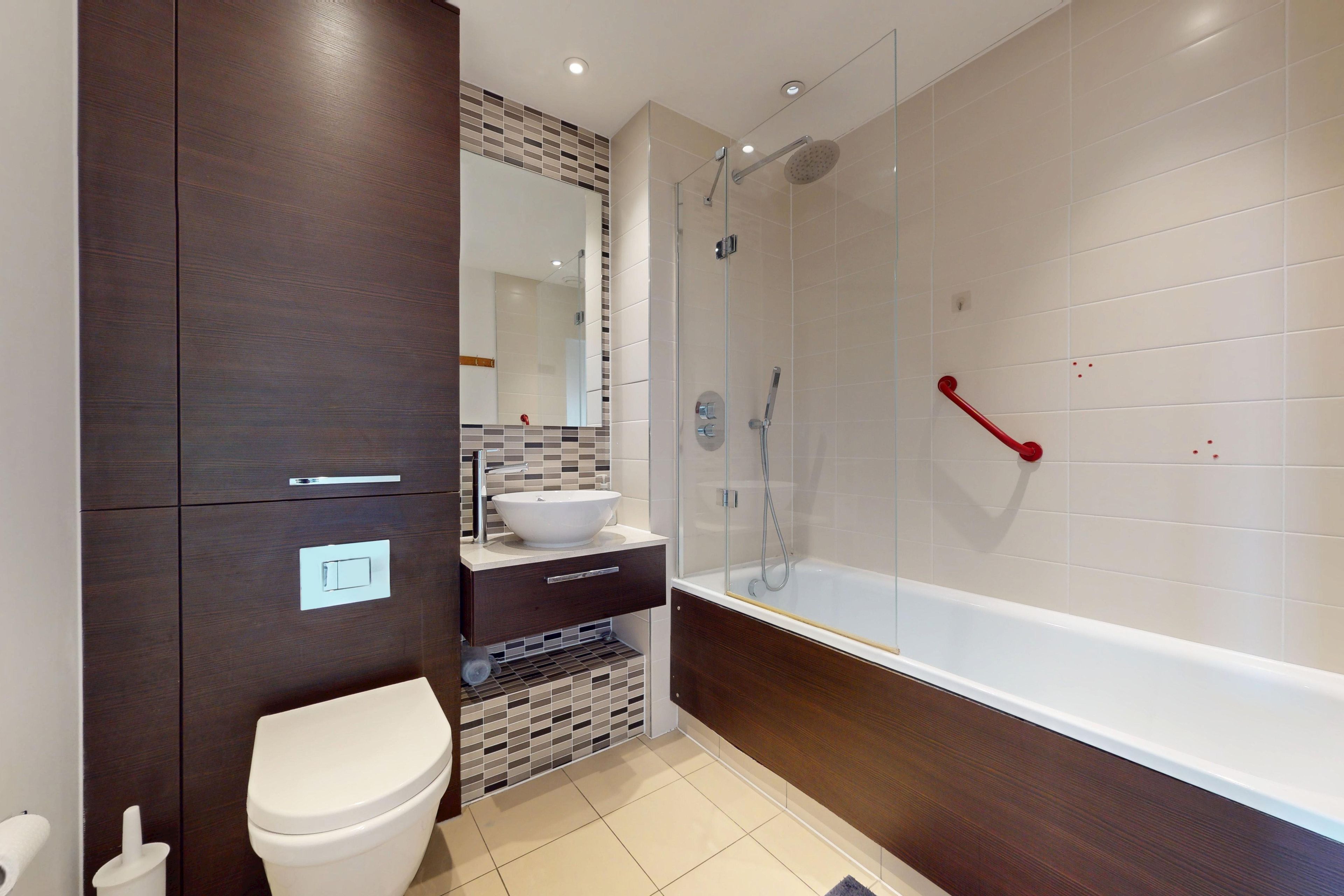 A modern bathroom with a toilet, sink, and shower area.