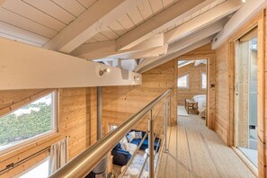 Interior de madeira com escada que leva a um quarto.