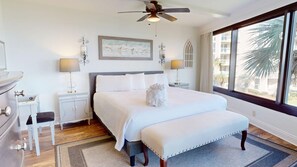 A hotel room with a large bed, a ceiling fan, a window with a view, and a painting on the wall. - Beachside One 4037, New to Rental Program, Gulf Front (Miramar Beach)