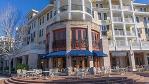 A multi-story hotel with outdoor seating and a central courtyard. - Luau 2 6622/6624LO, New to Rentals, Pool Views, (Miramar Beach)