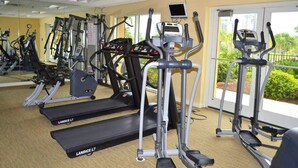 A gym with multiple Landice L7 treadmills, a digital display, and a view of greenery outside. - Luau 2 6622/6624LO, New to Rentals, Pool Views, (Miramar Beach)