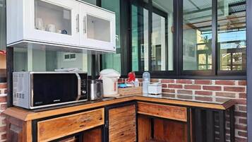 Une cuisine équipée d’un four à micro-ondes, d’une machine à café et d’un placard.