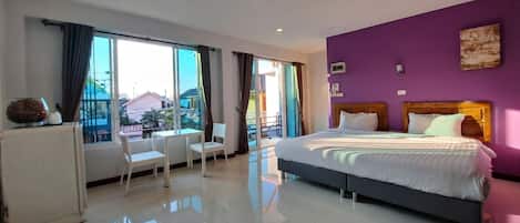 A modern hotel room with a large bed, a desk, and a chair.