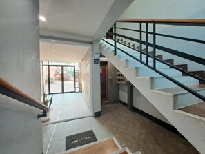 Interior moderno com escada, área de recepção e vista para o exterior.