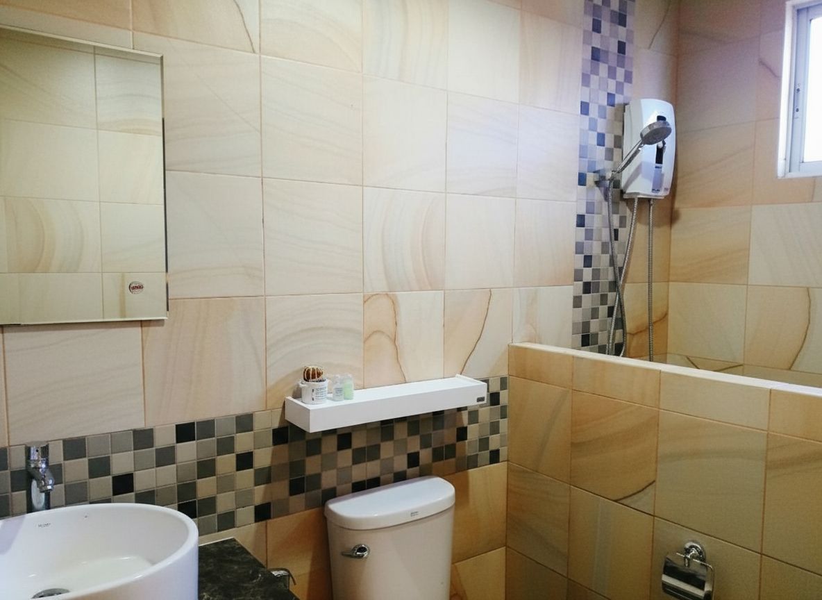 A bathroom with a white sink, a toilet, and a shower area.
