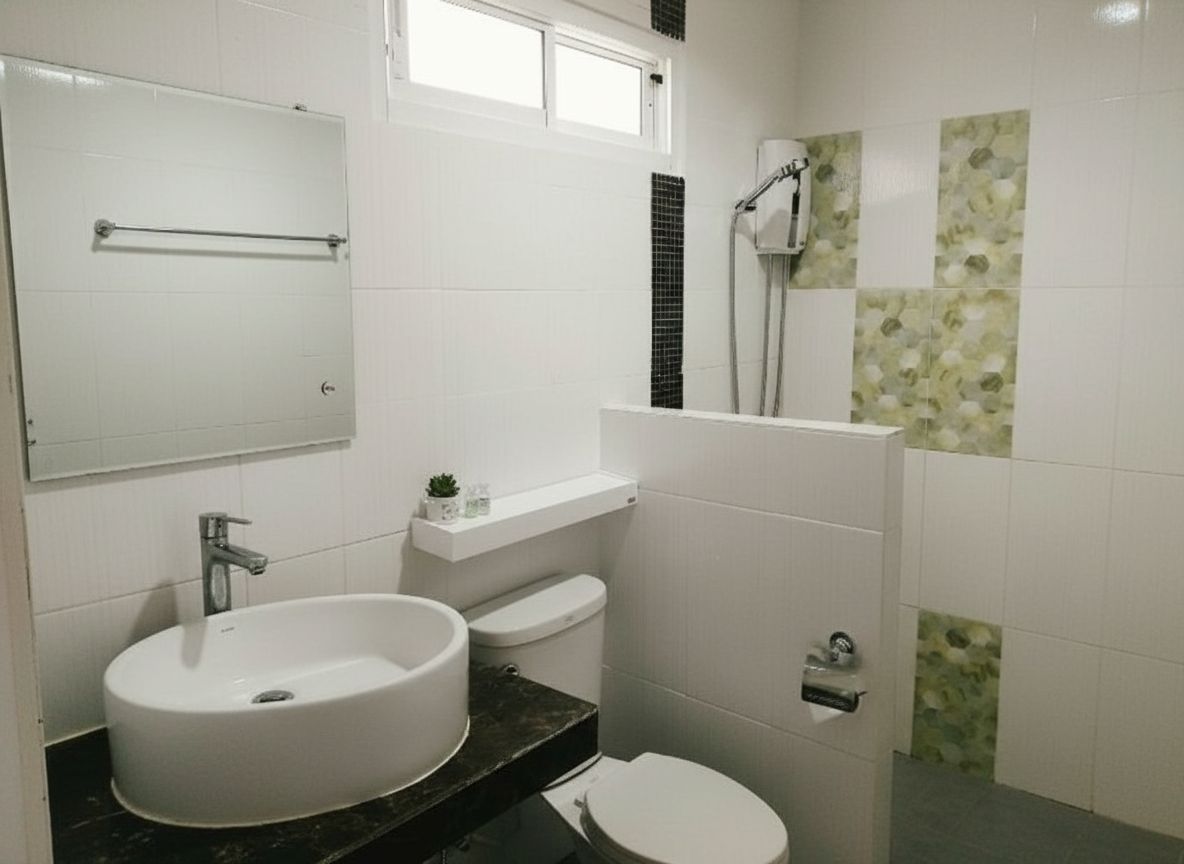 A bathroom with a white sink, toilet, and shower.