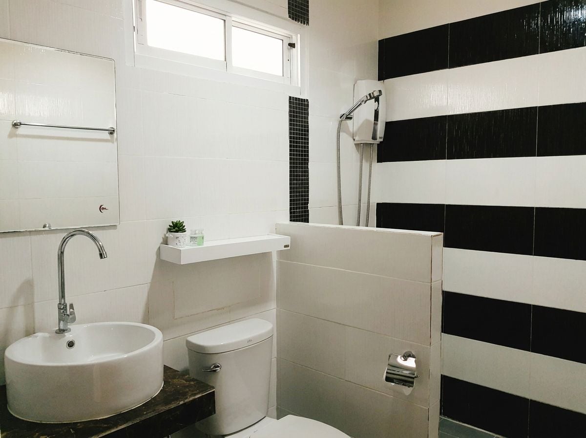 A bathroom with a white sink, toilet, and shower.