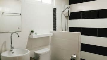 A bathroom with a white sink, toilet, and shower.
