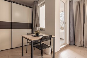 Cocina moderna con comedor, con una mesa, sillas, una planta en maceta y vistas a través de una ventana.