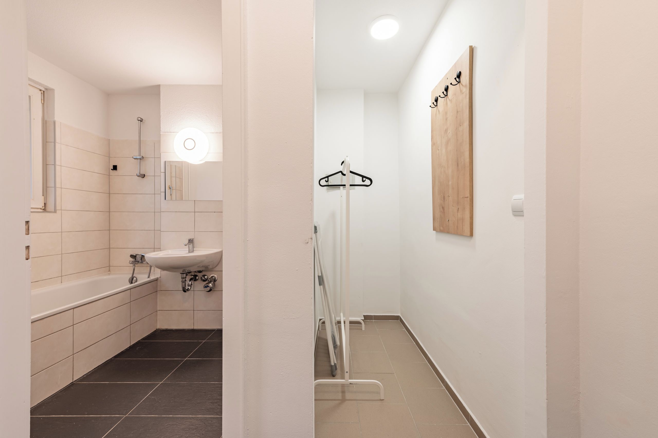 A modern bathroom with a bathtub, sink, and shower.