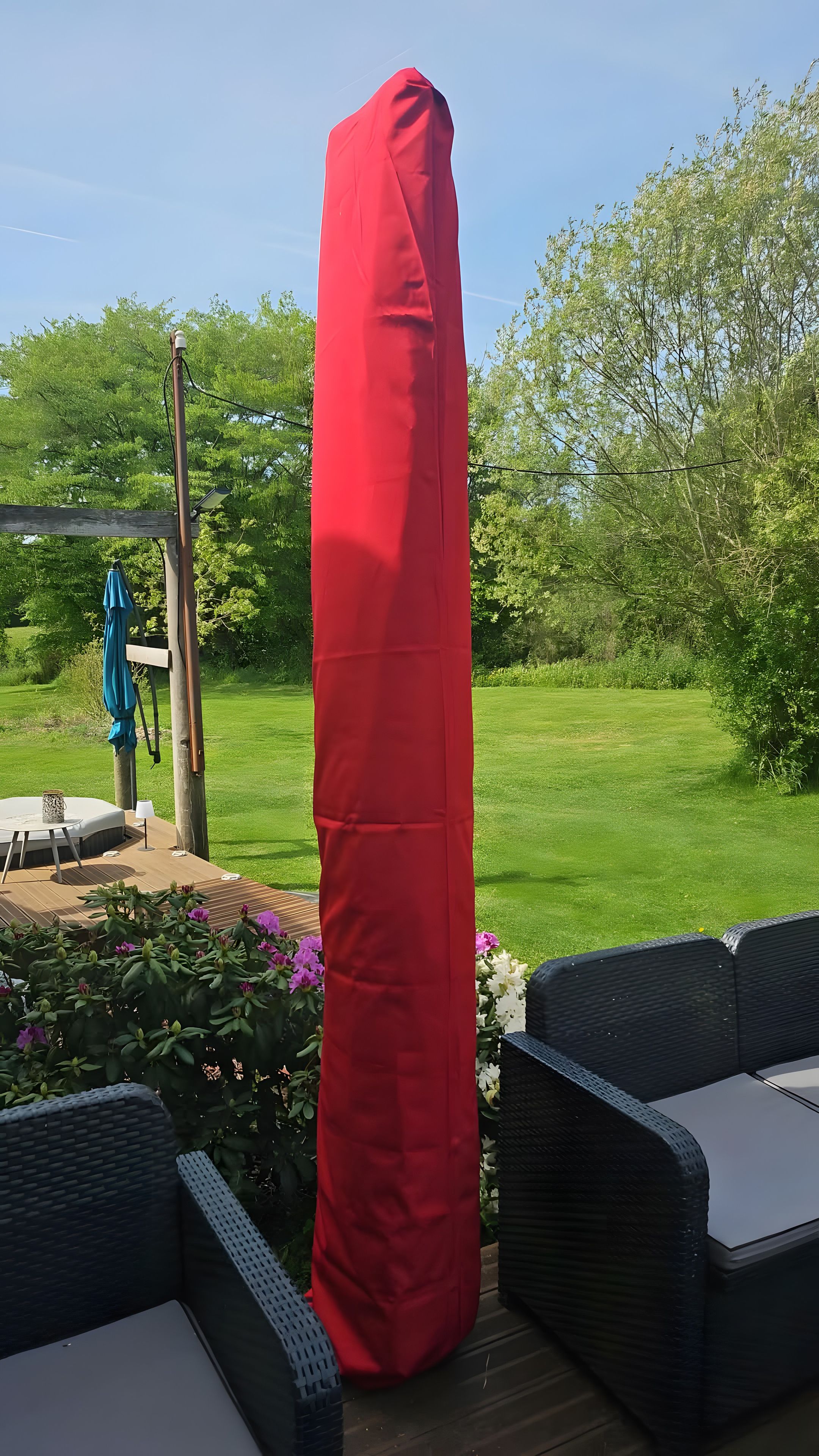 Un espacio de estar techado al aire libre con vistas a un césped y árboles.