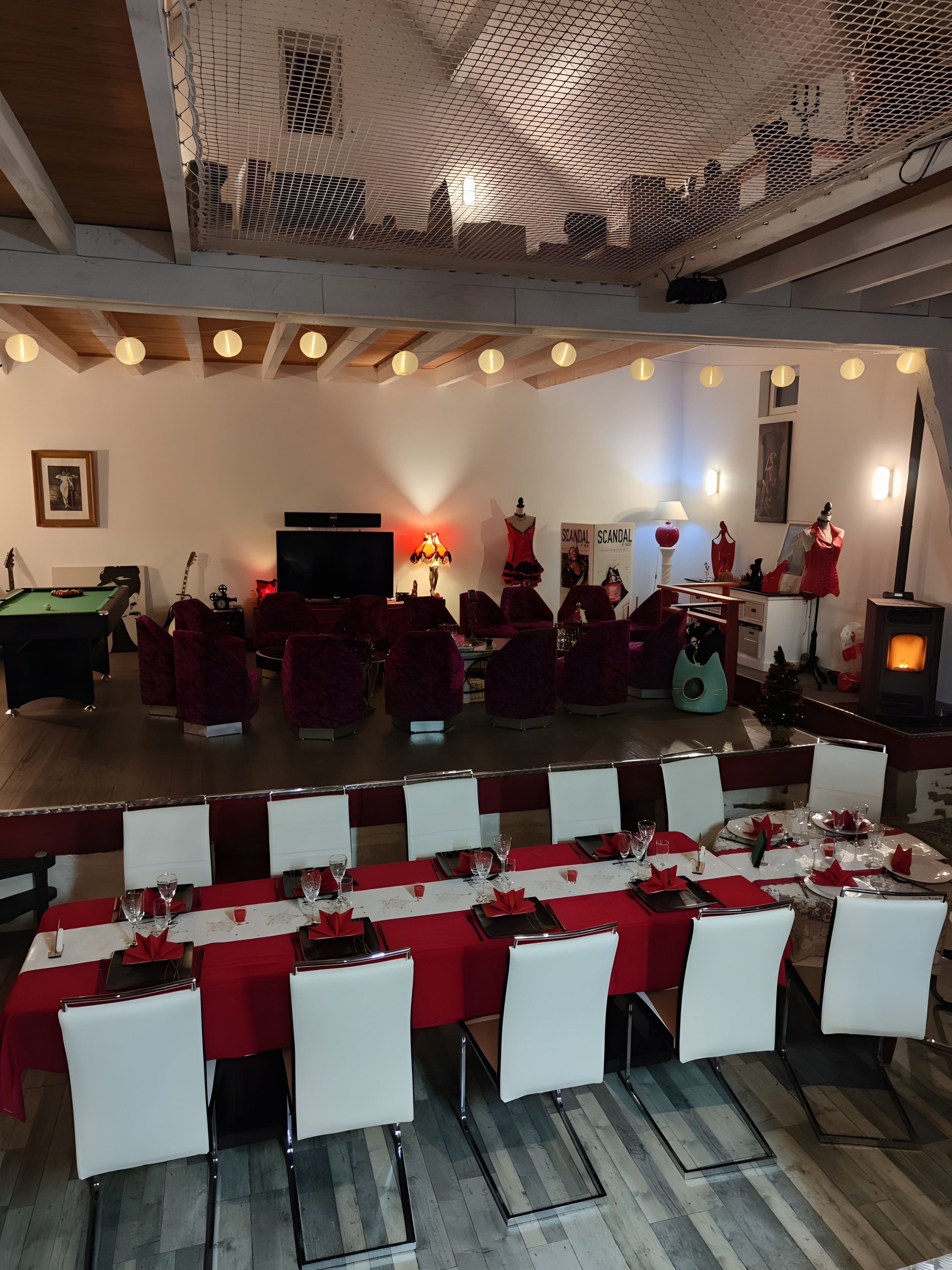 Un salón de conferencias con escenario, sillas blancas y mesas dispuestas para un evento formal.