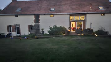Une maison à deux étages, dotée d’un toit en pente, d’une entrée principale et d’un escalier apparent menant à l’étage supérieur.