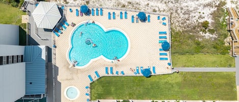Piscina en la azotea con varios sillones de tomar el sol y un jacuzzi circular.