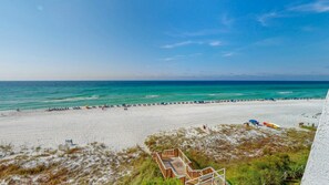 A beach with a wooden boardwalk leading to a building. - Beach House 401a 2 Bedroom Condo (Miramar Beach)