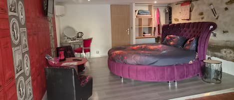 Un dormitorio con cama, escritorio, silla y armario.