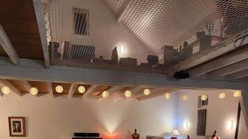 Une salle de conférence équipée d’une scène, de chaises blanches et de tables disposées pour un événement officiel.