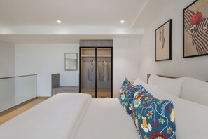 Un dormitorio moderno con una cama grande, un vestidor y vistas a la ciudad.