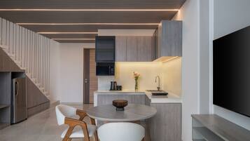 Una cocina moderna con comedor, televisor de pantalla plana y escalera.