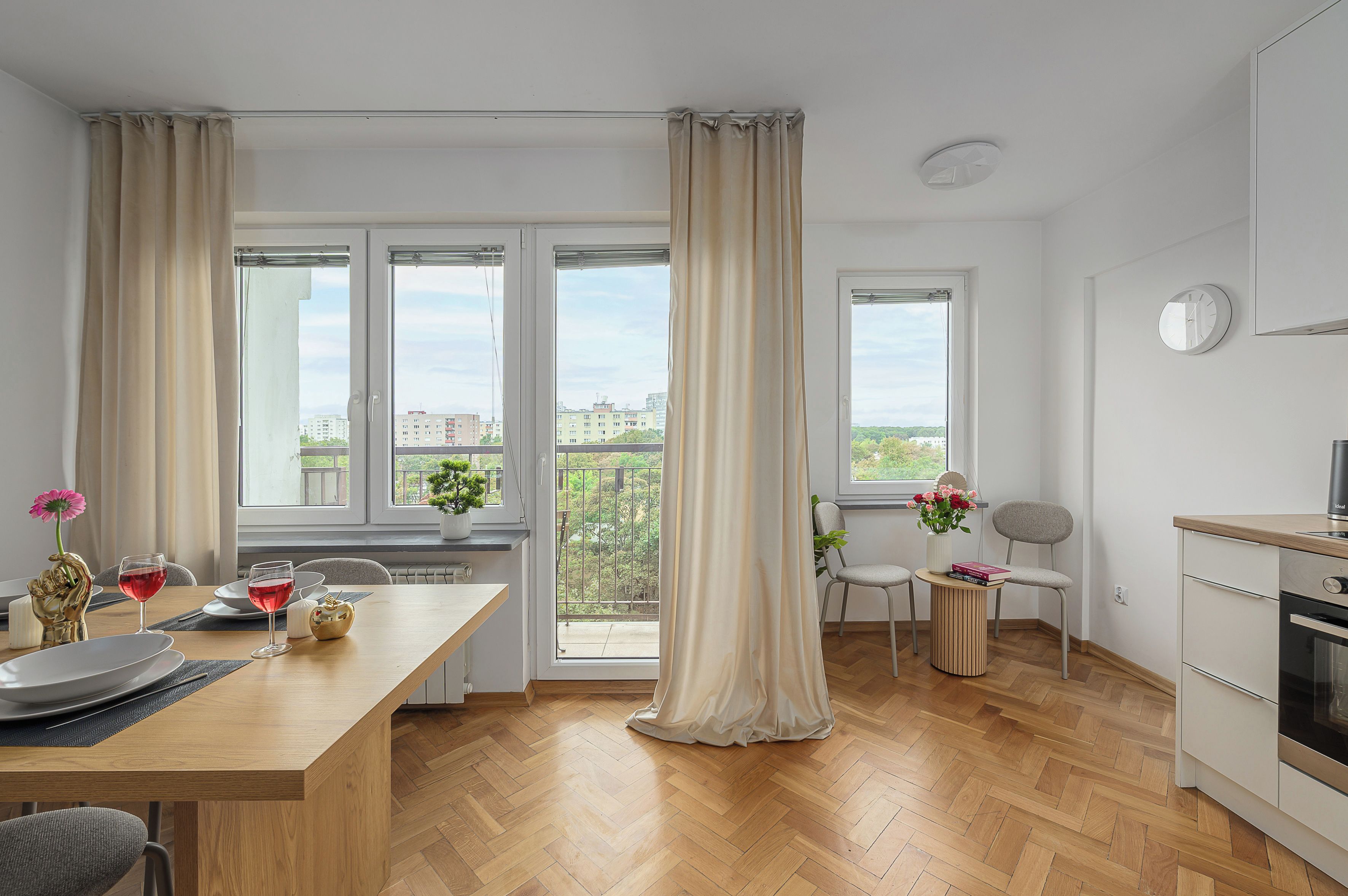Eine moderne Küche mit Essbereich, großen Fenstern und Blick auf die Stadt.