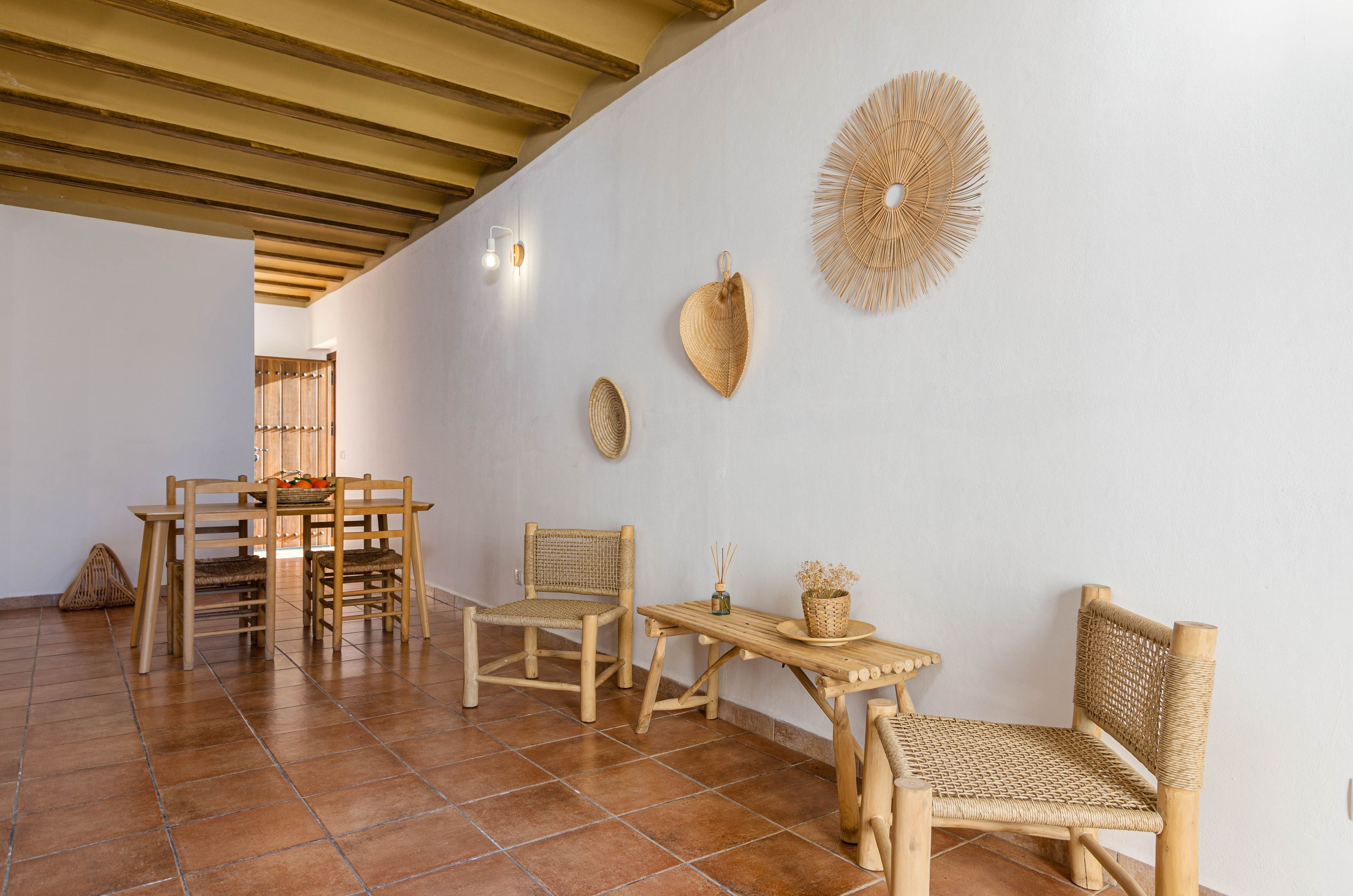 Una habitación con techo de madera, una mesa de comedor con sillas y decoración en las paredes.