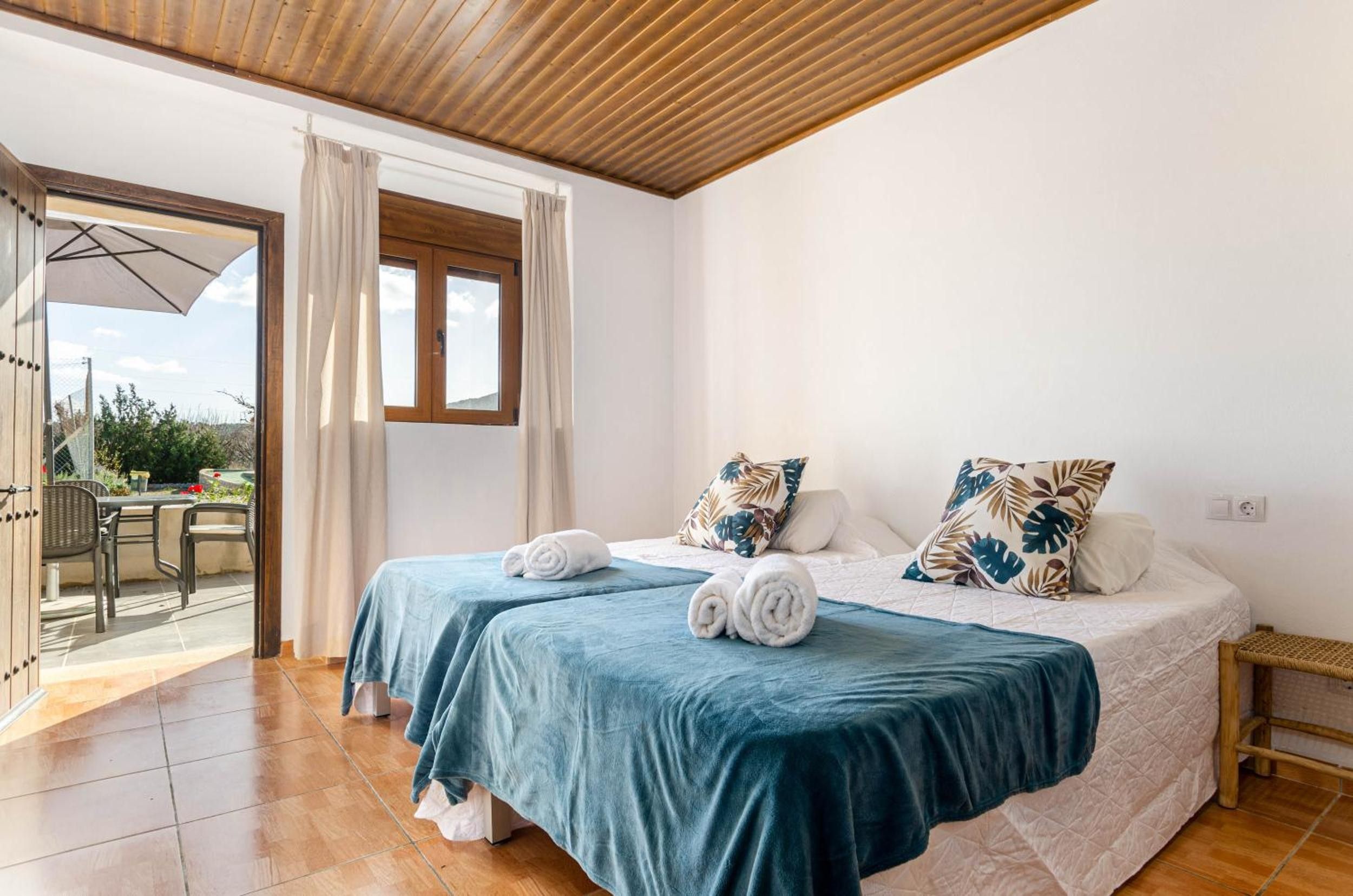 Un dormitorio con dos camas, un balcón y vistas al exterior.